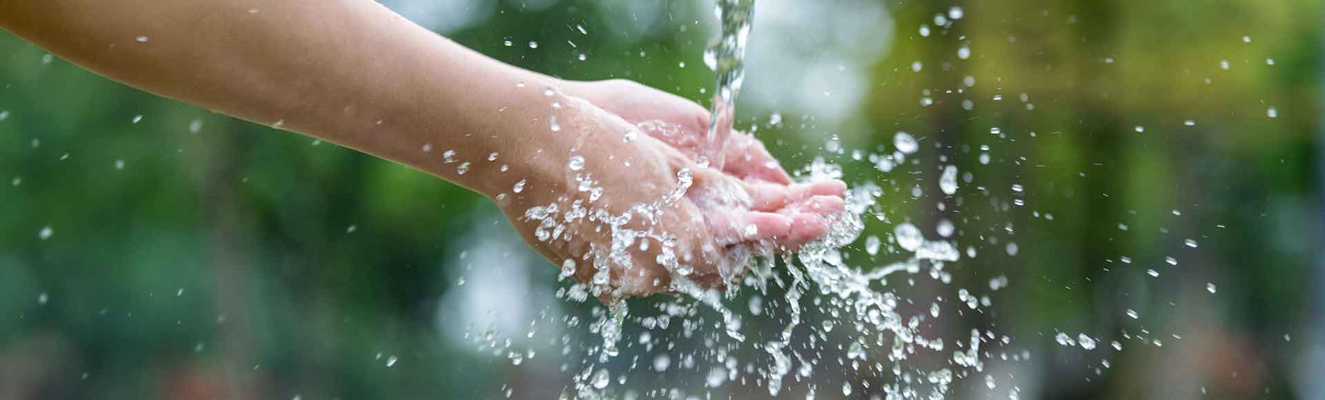 Woman washing hands under flowing water
